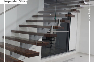 Photo of a mid-sized wood staircase in Sydney with glass risers.