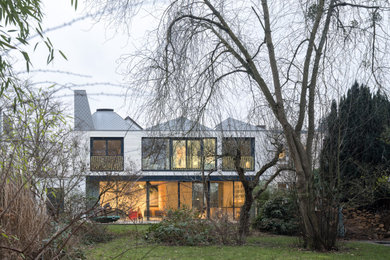 Inspiration for a large and white modern two floor detached house in Berlin with wood cladding, a hip roof, a metal roof, a grey roof and shiplap cladding.