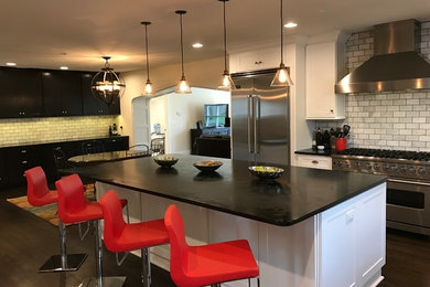 Expansive modern l-shaped eat-in kitchen in Nashville with recessed-panel cabinets, white cabinets, marble benchtops, white splashback, marble splashback, stainless steel appliances, dark hardwood floors, with island, brown floor and a farmhouse sink.