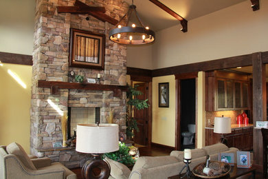 Living room - mid-sized rustic medium tone wood floor and brown floor living room idea in Other with beige walls, a standard fireplace and a stone fireplace