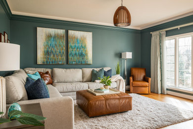 Immagine di un soggiorno chic di medie dimensioni e aperto con pareti verdi, pavimento in legno massello medio, porta TV ad angolo e pavimento marrone