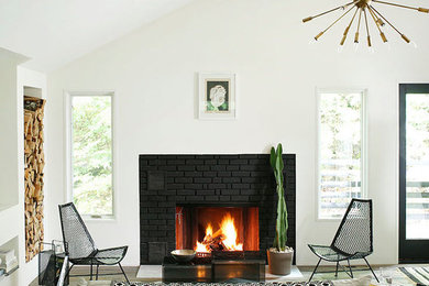 Mid-sized trendy enclosed light wood floor living room photo in Other with white walls, a standard fireplace and a brick fireplace