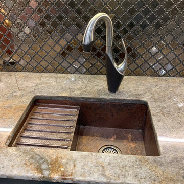 Copper bar sink paired with metallic backsplash