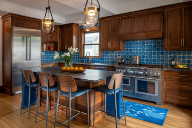 Inspiration for a mid-sized transitional l-shaped medium tone wood floor, brown floor and coffered ceiling enclosed kitchen remodel in Minneapolis with a single-bowl sink, flat-panel cabinets, medium tone wood cabinets, soapstone countertops, blue backsplash, ceramic backsplash, stainless steel appliances, an island and gray countertops