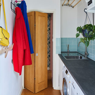 ロンドンのミッドセンチュリースタイルのおしゃれな洗濯室 (ドロップインシンク、白い壁、コルクフローリング、左右配置の洗濯機・乾燥機、グレーのキッチンカウンター) の写真