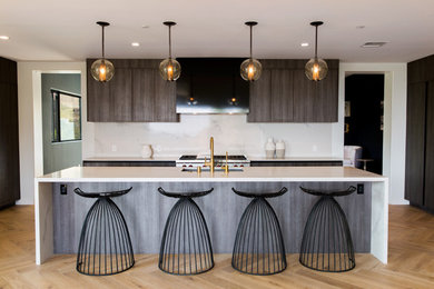 Inspiration for a large modern u-shaped light wood floor and brown floor open concept kitchen remodel in Los Angeles with an undermount sink, flat-panel cabinets, dark wood cabinets, marble countertops, gray backsplash, glass sheet backsplash, stainless steel appliances, an island and white countertops