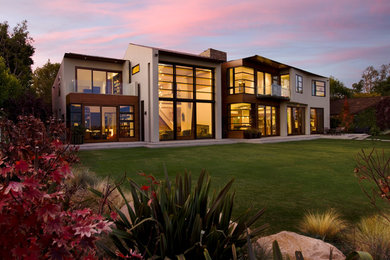 Contemporary brown two-story stucco exterior home idea in Los Angeles with a shed roof