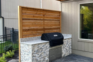 Patio - large modern backyard stamped concrete patio idea in Kansas City with a bbq area and a pergola