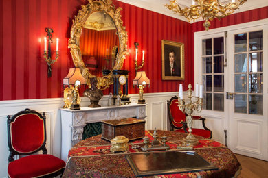 Inspiration pour un salon traditionnel avec un mur rouge et une cheminée standard.