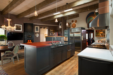 Photo of a contemporary galley eat-in kitchen in Albuquerque with shaker cabinets, grey cabinets, solid surface benchtops, stainless steel appliances, light hardwood floors and with island.