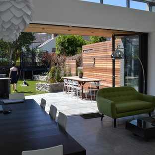 Inspiration för ett mellanstort funkis allrum med öppen planlösning, med vita väggar, betonggolv och en dold TV