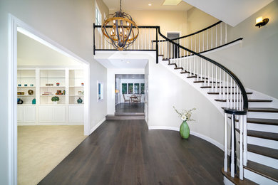 This is an example of an expansive arts and crafts foyer in San Francisco with grey walls, dark hardwood floors, a red front door and brown floor.