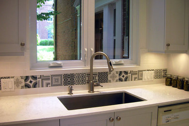 Eat-in kitchen - small scandinavian galley porcelain tile eat-in kitchen idea in Montreal with a single-bowl sink, shaker cabinets, white cabinets, quartzite countertops, white backsplash, ceramic backsplash, stainless steel appliances and no island