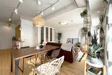 Immagine di una sala da pranzo aperta verso il soggiorno nordica con pareti bianche, parquet chiaro e pavimento beige