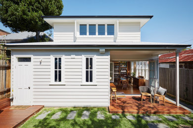 Photo of a mid-sized traditional two-storey white house exterior in Sydney with wood siding, a gable roof and a metal roof.