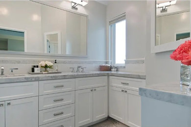 Mid-sized elegant master white tile and ceramic tile bathroom photo with recessed-panel cabinets, white cabinets, white walls, an integrated sink, marble countertops and gray countertops