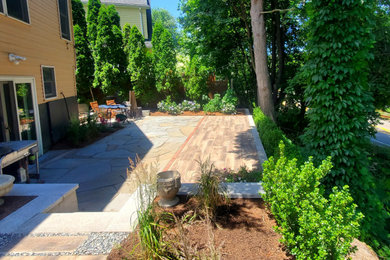 Ejemplo de jardín grande en patio trasero con exposición parcial al sol y adoquines de piedra natural