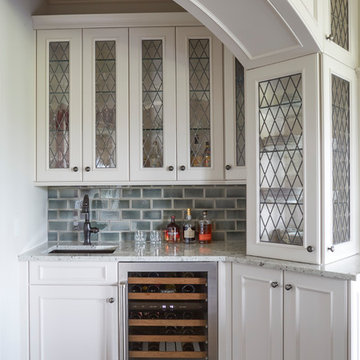 Wet Bar with Arched Opening and Glass Fronted Cabinetry