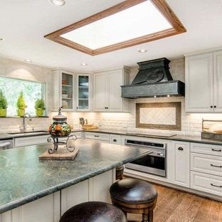 Design ideas for a large traditional kitchen pantry in DC Metro with shaker cabinets, white cabinets, quartz benchtops, white splashback, ceramic splashback, stainless steel appliances, dark hardwood floors, brown floor and green benchtop.