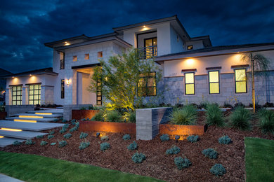 Large transitional white two-story stone house exterior idea in Other with a hip roof, a tile roof and a black roof