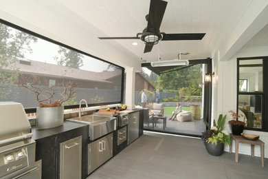 Photo of a country backyard patio in Seattle with an outdoor kitchen and an awning.