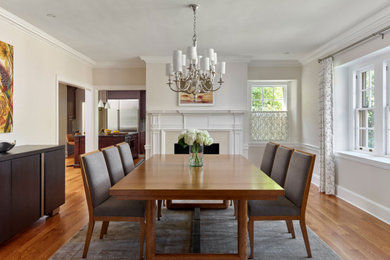 Inspiration for a mid-sized transitional medium tone wood floor kitchen/dining room combo remodel in Philadelphia with white walls, a standard fireplace and a wood fireplace surround