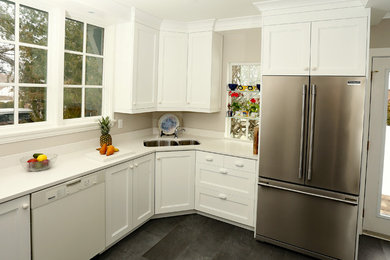 Example of a mid-sized transitional u-shaped vinyl floor and gray floor enclosed kitchen design in Toronto with an undermount sink, shaker cabinets, white cabinets, quartz countertops, white backsplash, stainless steel appliances and no island