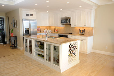 Eat-in kitchen - mid-sized transitional l-shaped porcelain tile eat-in kitchen idea in Miami with an undermount sink, shaker cabinets, white cabinets, granite countertops, beige backsplash, porcelain backsplash, stainless steel appliances and an island