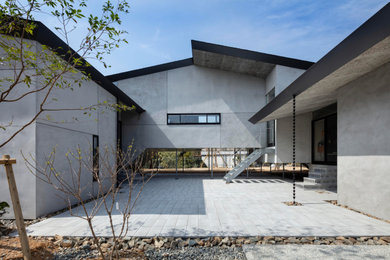 Cette photo montre une grande terrasse avec une cour, une dalle de béton et une extension de toiture.