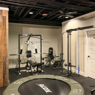 This is an example of a large rural walk-out basement in Chicago with beige walls, vinyl flooring and black floors.