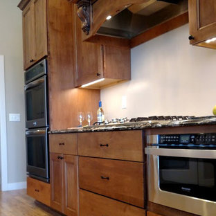 Idéer för ett klassiskt kök, med luckor med infälld panel, skåp i mellenmörkt trä, granitbänkskiva, rostfria vitvaror, målat trägolv och en halv köksö