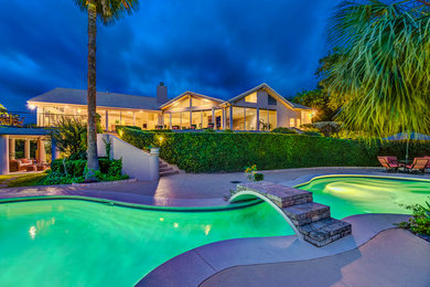 Inspiration for a large coastal backyard concrete paver and custom-shaped hot tub remodel in Austin