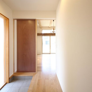 Idee per un corridoio etnico di medie dimensioni con pareti bianche, pavimento in compensato, una porta singola, una porta in legno bruno e pavimento marrone