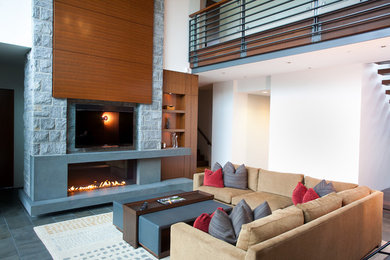 Inspiration for a large contemporary open concept family room in Vancouver with beige walls, a ribbon fireplace, a built-in media wall, light hardwood floors and a concrete fireplace surround.
