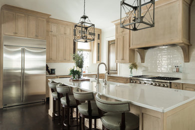 Inspiration for a transitional kitchen in Nashville with a farmhouse sink, beaded inset cabinets, light wood cabinets, quartzite benchtops, white splashback, subway tile splashback, stainless steel appliances, dark hardwood floors, with island and brown floor.