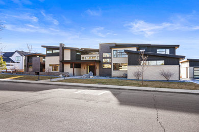 Modern two-story brick exterior home idea in Denver with a metal roof and a black roof