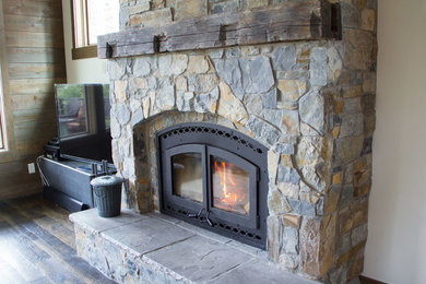 Living room - large rustic dark wood floor living room idea in Salt Lake City with white walls, a standard fireplace and a stone fireplace