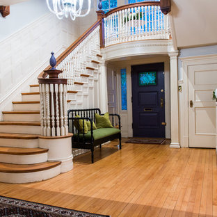 Bild på en mellanstor eklektisk foajé, med grå väggar, ljust trägolv, en enkeldörr och en lila dörr