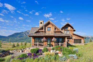 Inspiration for a rustic brown two-story wood exterior home remodel in Other with a metal roof and a gray roof