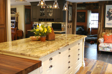 Example of a mid-sized arts and crafts l-shaped kitchen design in Boston with white cabinets, an island, recessed-panel cabinets, granite countertops, beige backsplash, stone tile backsplash and stainless steel appliances