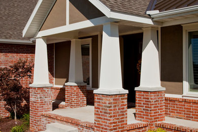 Large trendy one-story brick exterior home photo in Other with a shingle roof