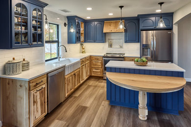 Mid-sized farmhouse l-shaped vinyl floor and gray floor eat-in kitchen photo in Other with a farmhouse sink, beaded inset cabinets, light wood cabinets, quartz countertops, white backsplash, brick backsplash, stainless steel appliances, an island and white countertops