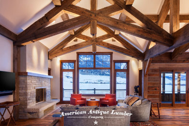 Large traditional open concept living room in Denver with medium hardwood floors, a standard fireplace, a stone fireplace surround, brown floor and exposed beam.