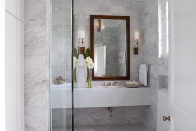 Photo of a small transitional bathroom in Chicago with an integrated sink, flat-panel cabinets, white cabinets, marble benchtops, an open shower, a one-piece toilet, stone tile, white walls, marble floors and gray tile.