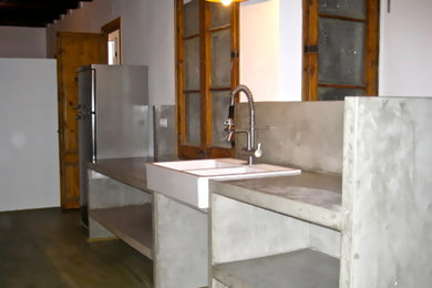Foto de cocina lineal moderna abierta con fregadero encastrado, encimera de cemento y salpicadero verde