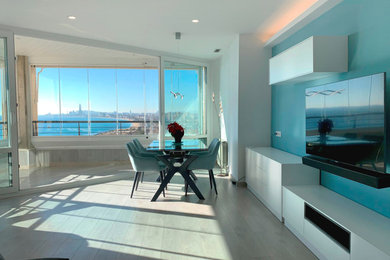 Imagen de comedor blanco mediterráneo de tamaño medio abierto con paredes azules, suelo de madera clara, suelo beige y bandeja