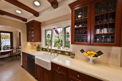 Example of an arts and crafts galley porcelain tile eat-in kitchen design in San Diego with a farmhouse sink, raised-panel cabinets, dark wood cabinets, quartz countertops, multicolored backsplash, white appliances and no island