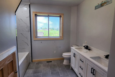 Mid-sized farmhouse master gray tile porcelain tile, gray floor and double-sink bathroom photo in Other with shaker cabinets, white cabinets, a two-piece toilet, a drop-in sink, quartzite countertops, a hinged shower door, white countertops, a niche and a freestanding vanity