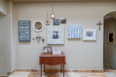 Mid-sized beach style travertine floor and multicolored floor foyer photo in San Diego with beige walls
