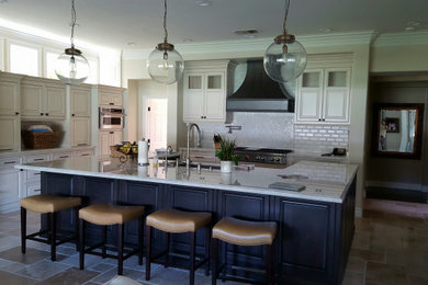 Eat-in kitchen - huge country limestone floor and beige floor eat-in kitchen idea in Charlotte with an undermount sink, beige cabinets, quartzite countertops, white backsplash, marble backsplash, stainless steel appliances, an island and white countertops